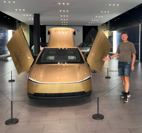 Ein goldenes Tesla Cybercab mit geöffneten Türen.